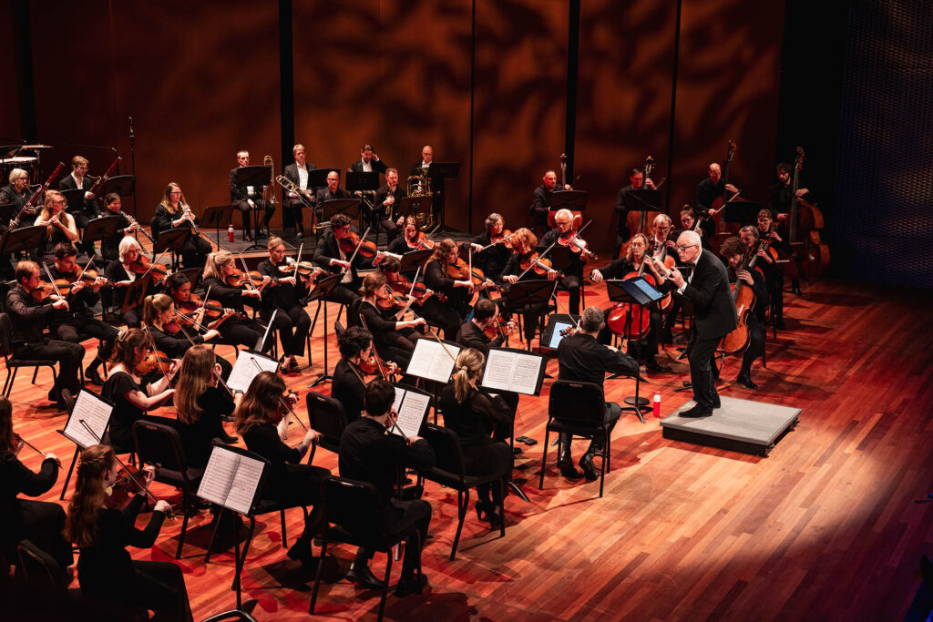 Flevolands Philharmonisch Orkest maakt muziek op een podium met dirigent Hans Welle