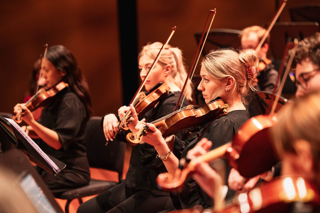 Violisten van het Flevolands Philharmonisch Orkest maken muziek